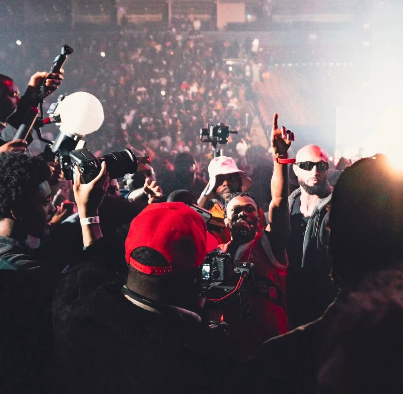 Photographers and fans filming from inside an arena crowd