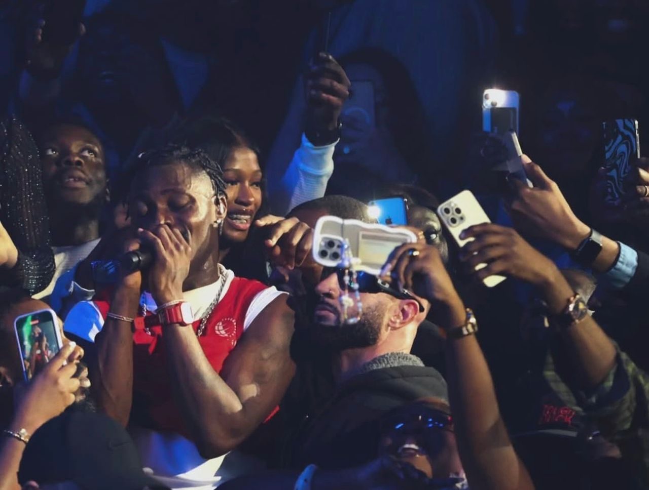 Fans filming an artist performing in the crowd