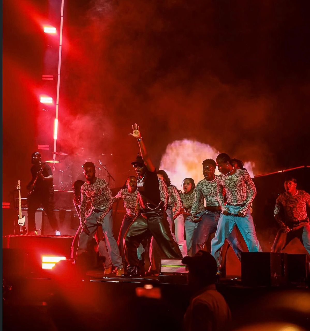 Headline act and dancers on a red-lit concert stage