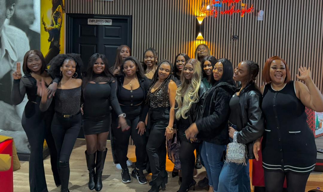Large group of friends in all-black posing at a night out