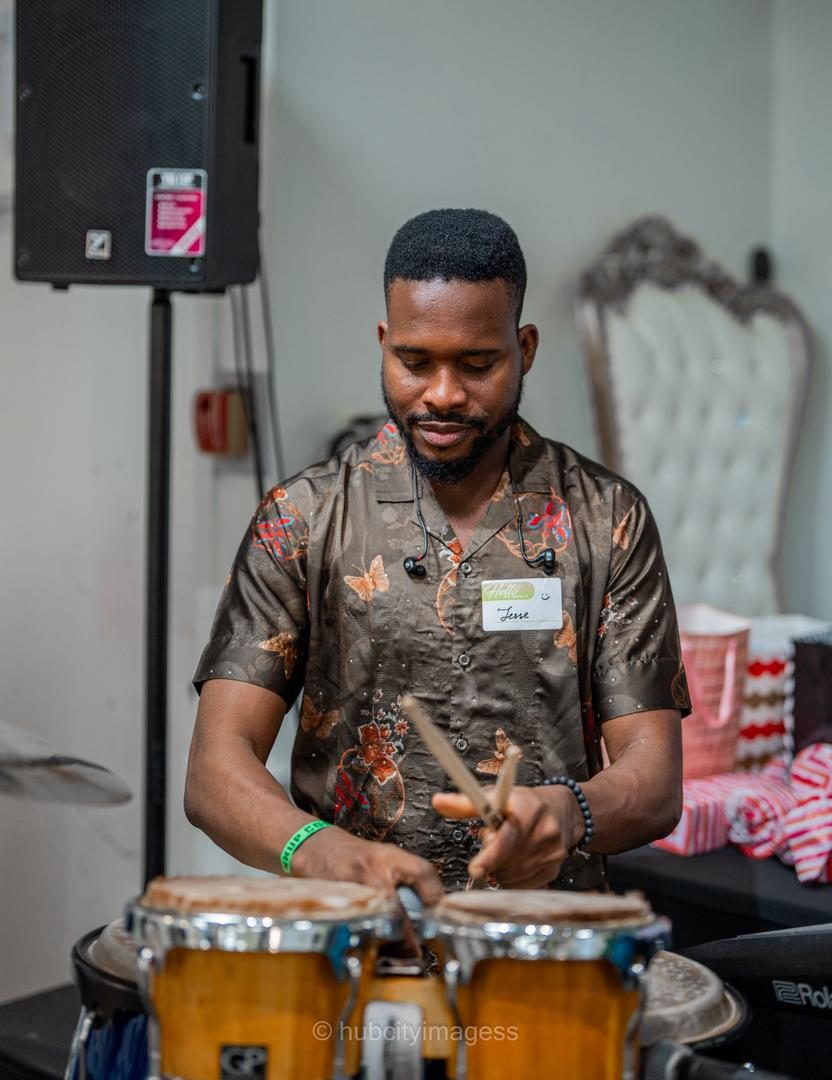 Percussionist playing bongos live at an indoor event