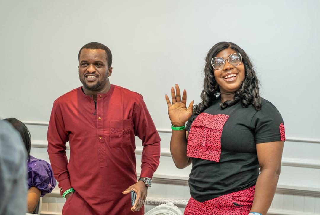 Hosts greeting the room at a community meet-up