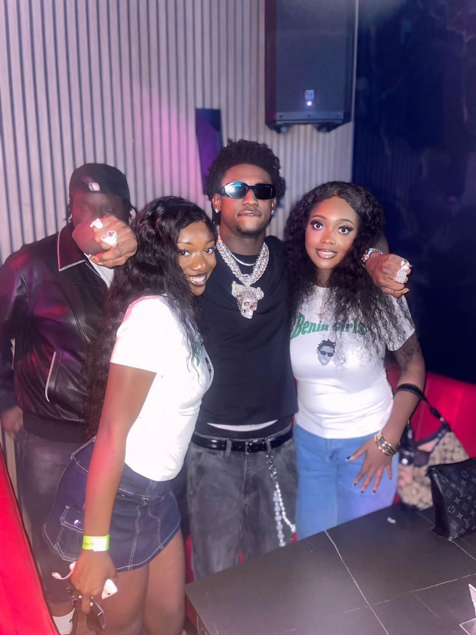 Three friends posing together at a nightlife party