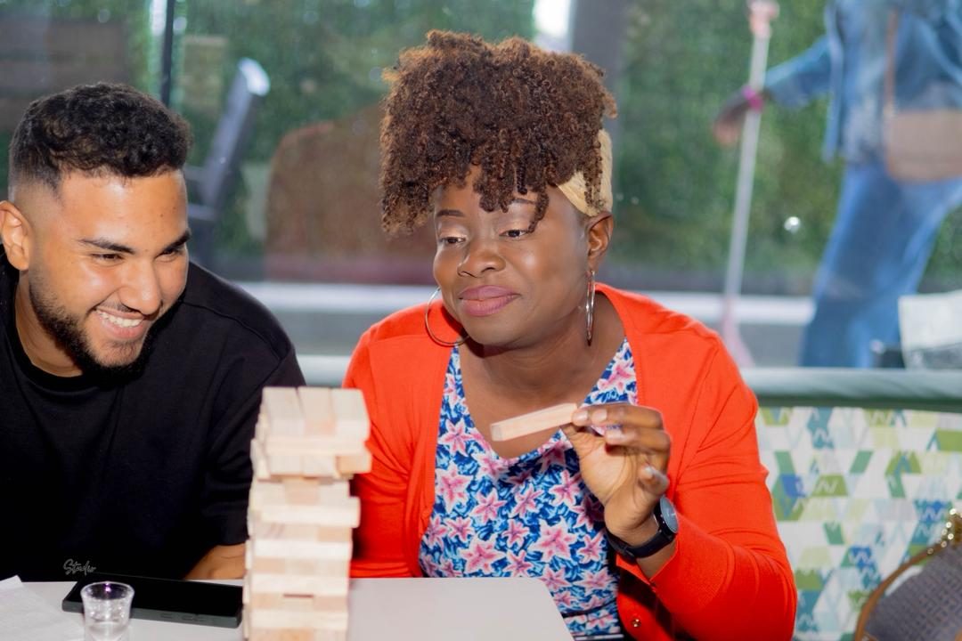 Guests playing a tower block game at a social meet-up