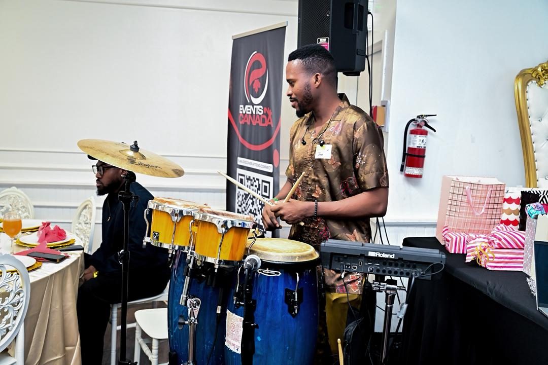Percussionist playing congas beside the Events in Canada banner