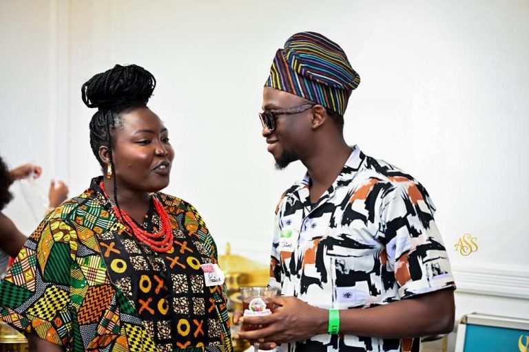 Two guests in colourful prints chatting at a reception