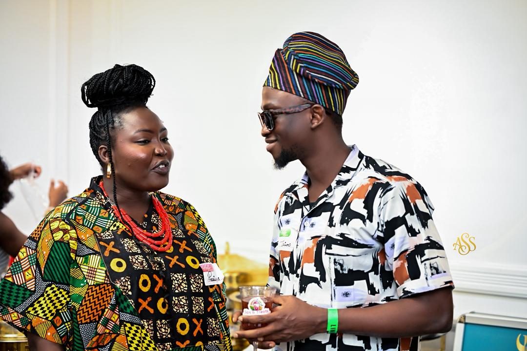 Two guests in traditional prints in conversation at a reception